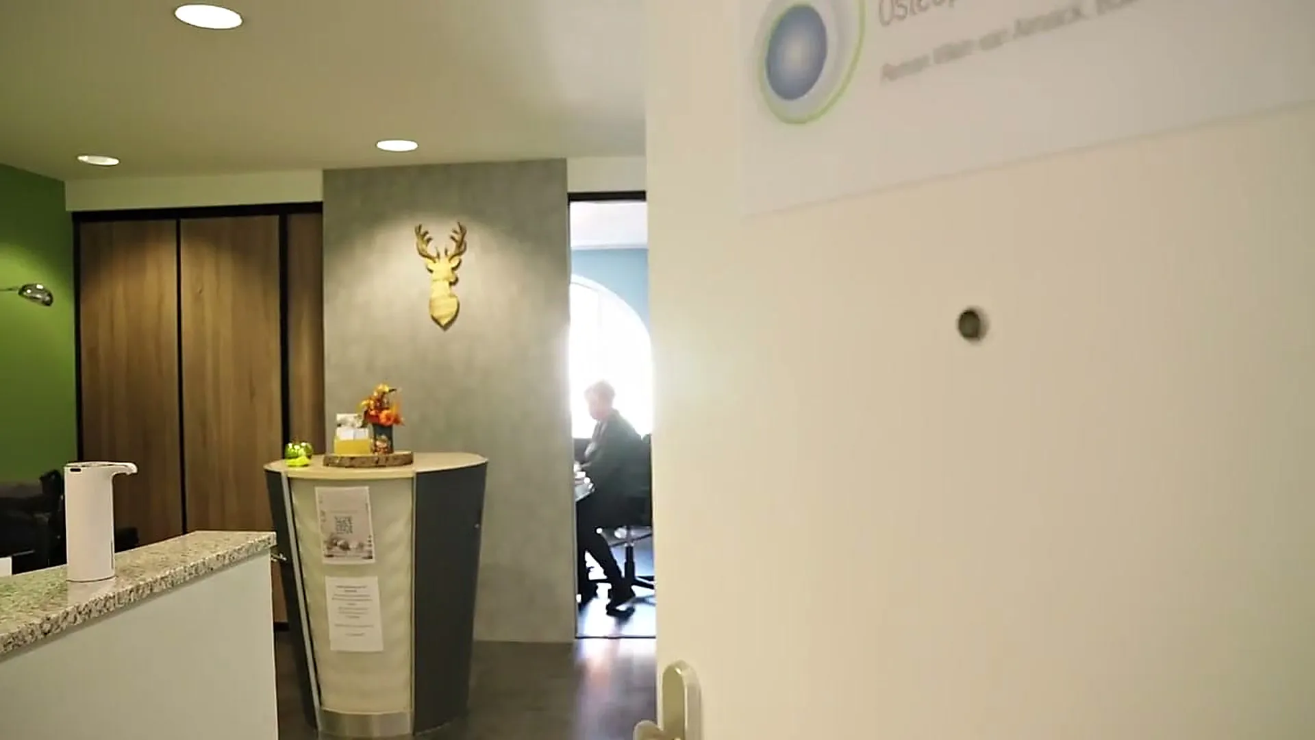 Eingangstür der Praxis mit dem Schild des Zentrums für Osteopathie und Gesundheit